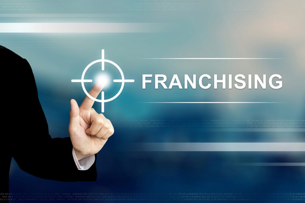business hand clicking franchising button on touch screen